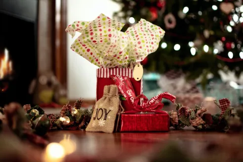 a small red gift bag with christmas tree in the background