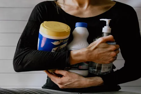 a person holding cleaning supplies