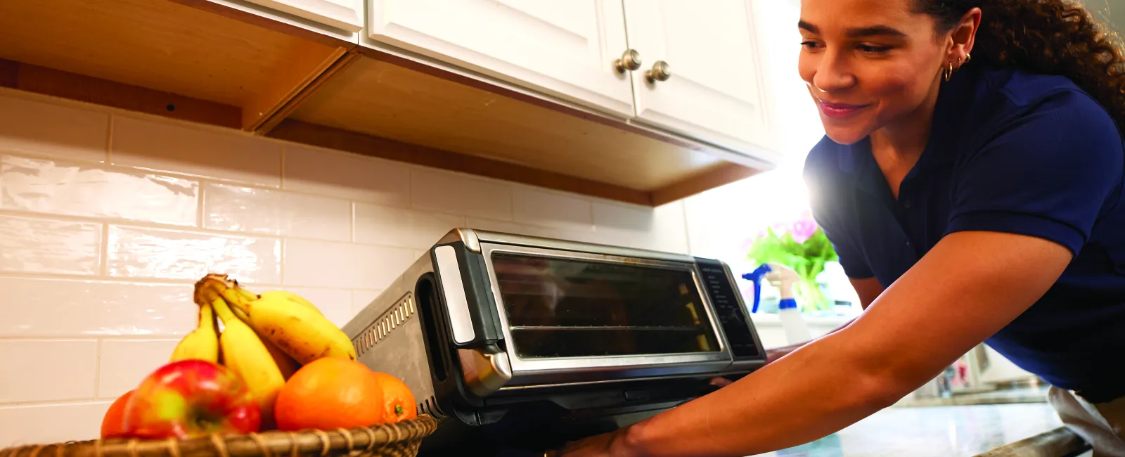 a person cleaning under toaster oven