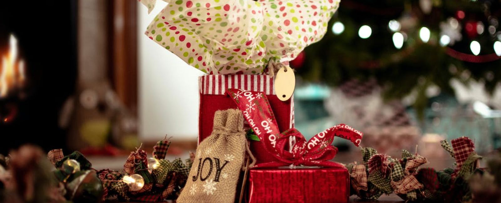 a small red gift bag with christmas tree in the background