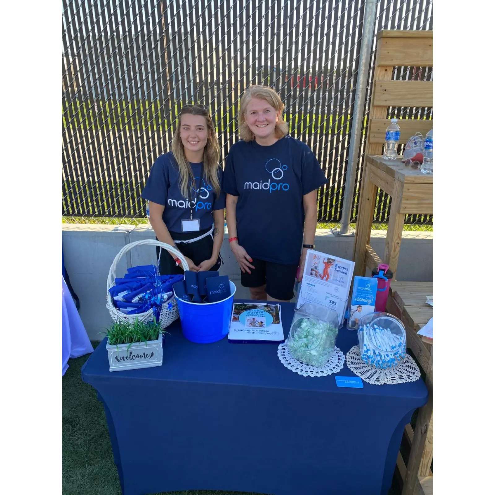 a couple of women standing next to a table with food and drinks