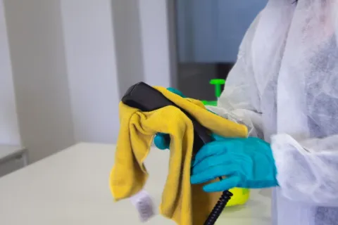 a person wearing gloves and holding a rag