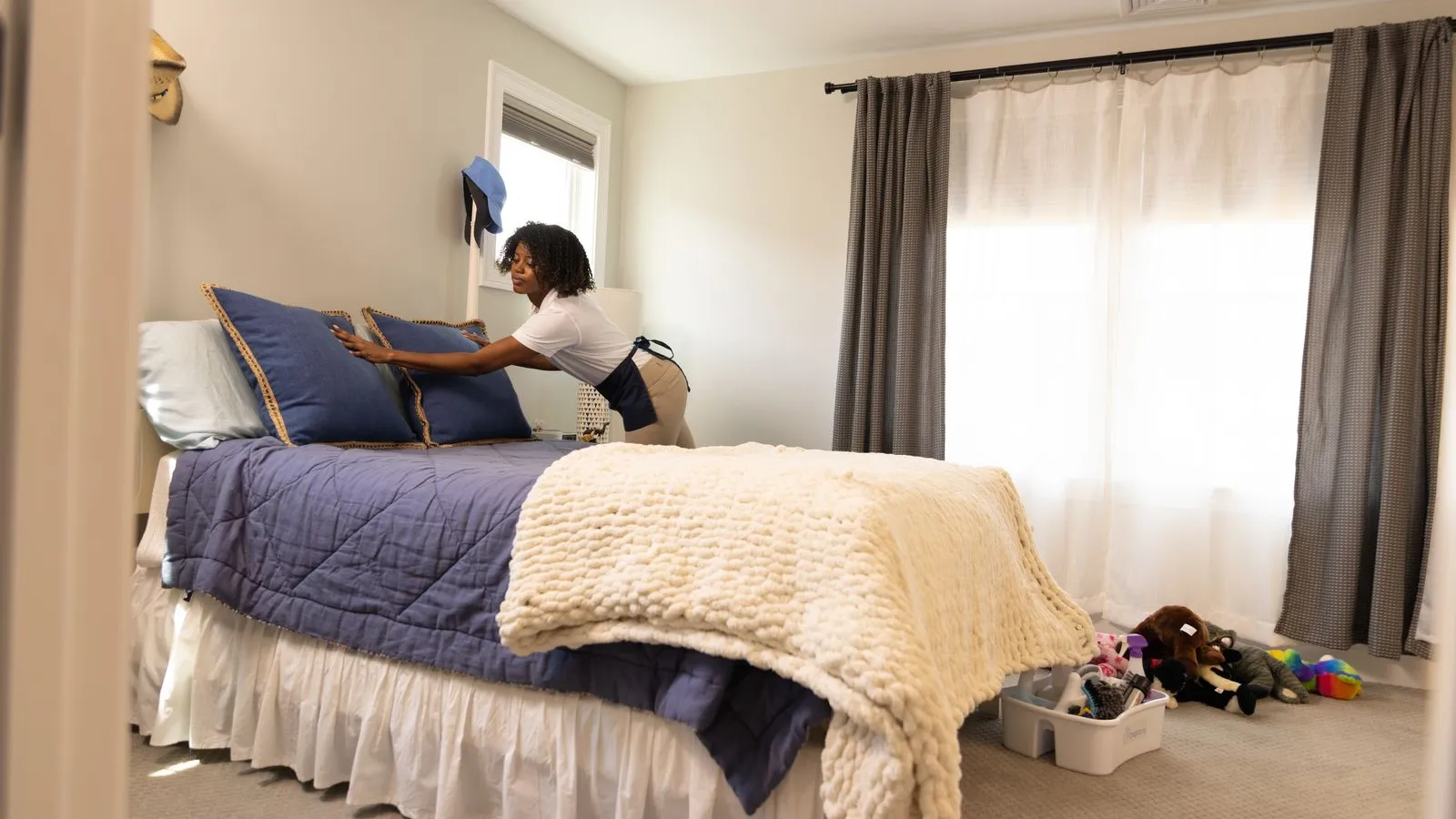 a person placing pillows on a bed