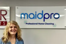 Thumbnail for a person smiling in front of a sign