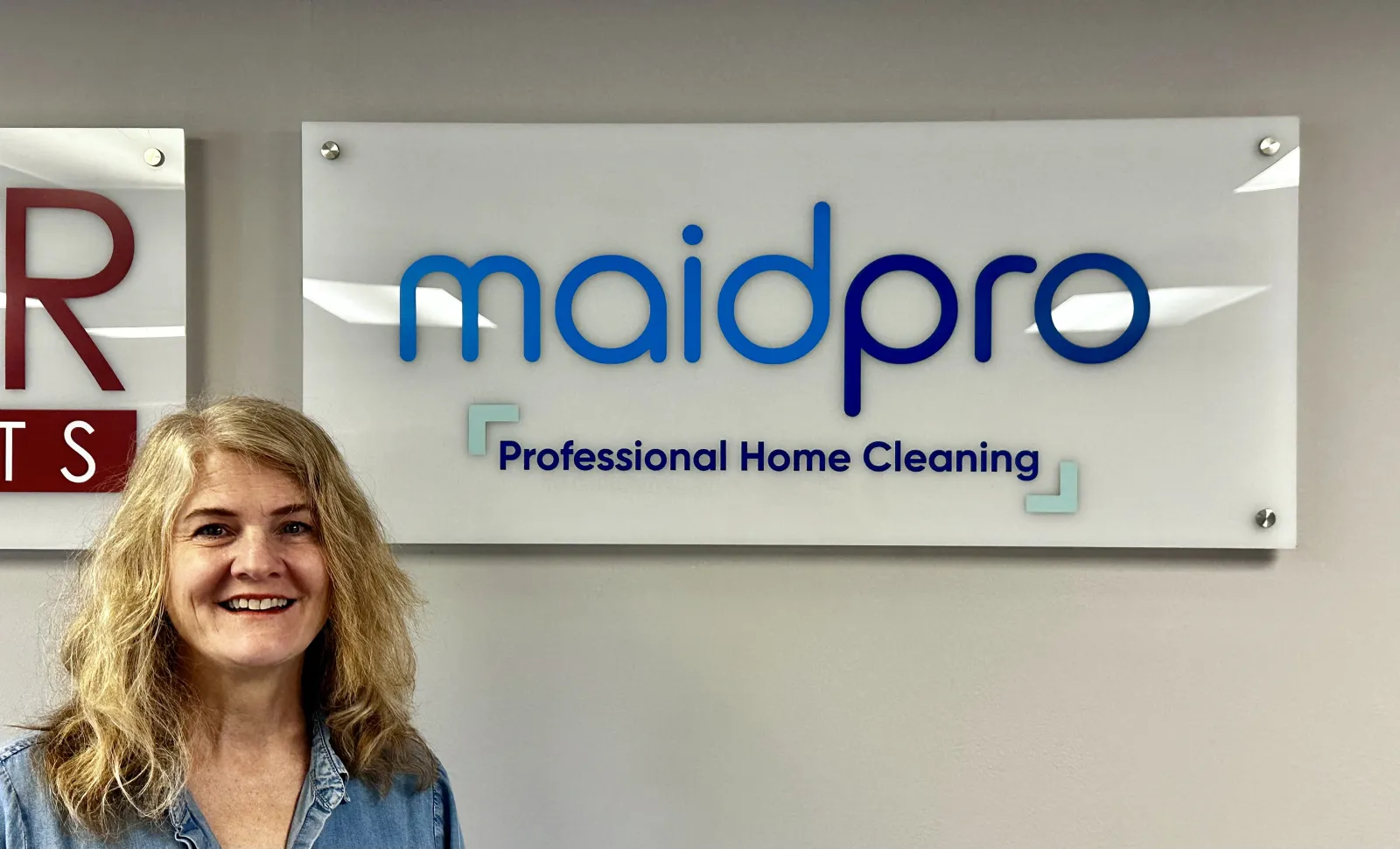 a person smiling in front of a sign